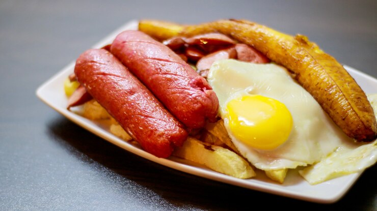 Foto plato de comida rápida plátanos patatas huevo salchicha frita