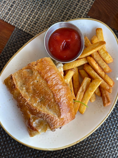 Foto un plato de comida con un sándwich y ketchup.