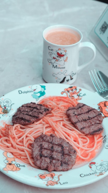 Un plato de comida con una taza de café y un plato de espagueti y carne