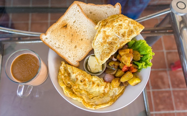 Un plato de comida con una taza de café sobre la mesa