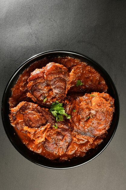 Un plato de comida con un trozo de carne dentro.