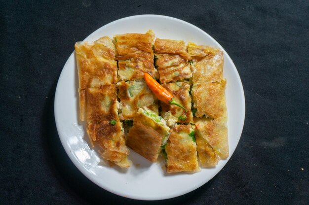 Un plato de comida con un trozo de pan encima.