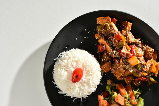 Un plato de comida con un trozo de pollo y arroz.