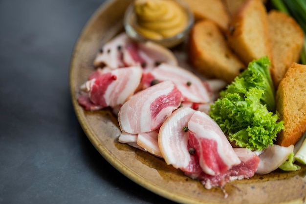 Plato de comida ucraniana de aperitivo con manteca de cerdo picada con cebollas verdes y mostaza con pan