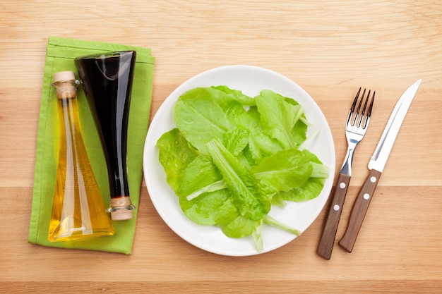 Plato con condimentos para ensalada fresca cuchillo y tenedor Comida dietética