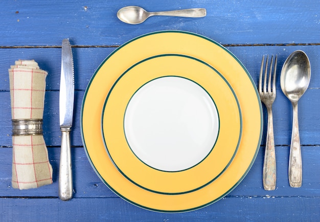 Foto plato con cubiertos de plata sobre una vieja mesa