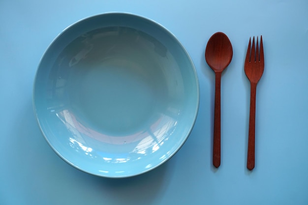 plato con cuchara y tenedor sobre fondo negro