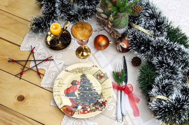 Plato cuchillo tenedor vidrio y una variedad de adornos navideños en un primer plano de la mesa