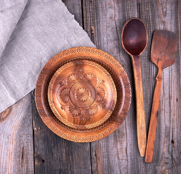 Plato decorativo redondo marrón tallado y cuchara de madera.