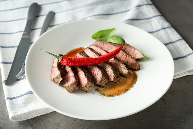 Plato con deliciosa carne en rodajas y salsa en la mesa