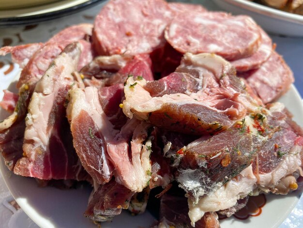 Un plato con deliciosa carne roja ahumada, jamón, tocino, manteca de cerdo, salchicha y cuello de cerdo.