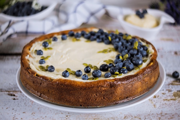 Foto plato con deliciosa tarta de arándanos en mesa blanca