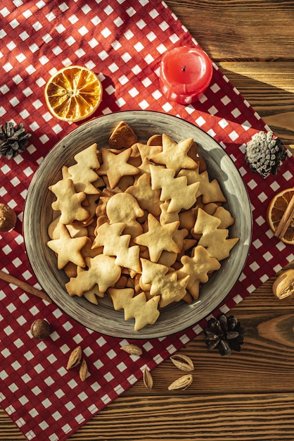 Un plato de deliciosas galletas caseras con forma de vacaciones sobre un mantel rojo sobre una mesa de madera