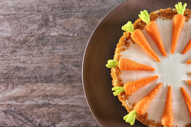 Plato con delicioso pastel de zanahoria sobre fondo de madera