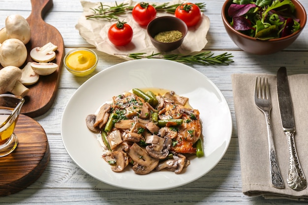 Plato con delicioso pollo marsala y verduras en mesa