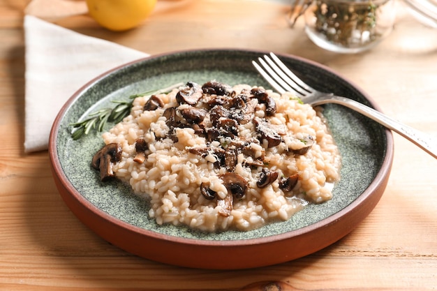 Plato con delicioso risotto y champiñones en la mesa