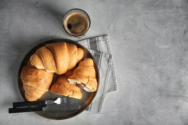 Plato con deliciosos croissants de chocolate fresco en la mesa