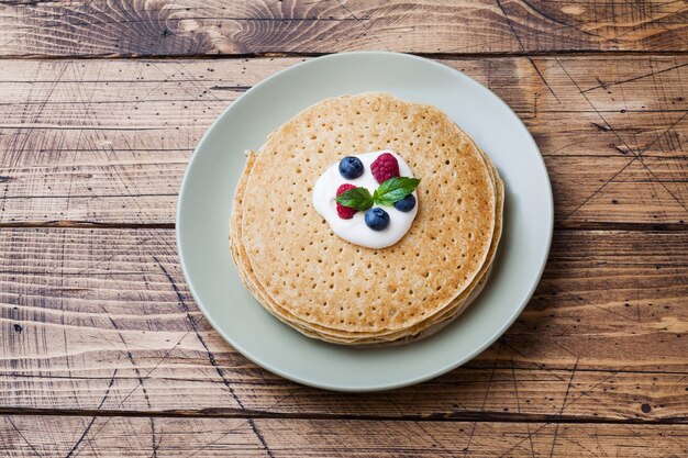 Foto plato con deliciosos panqueques con frutos rojos