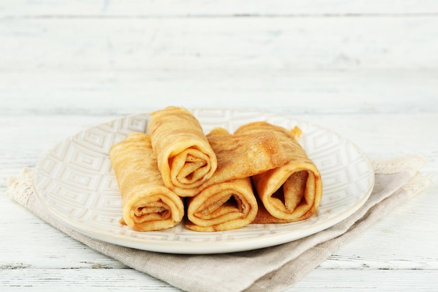 Plato de deliciosos panqueques sobre fondo de madera