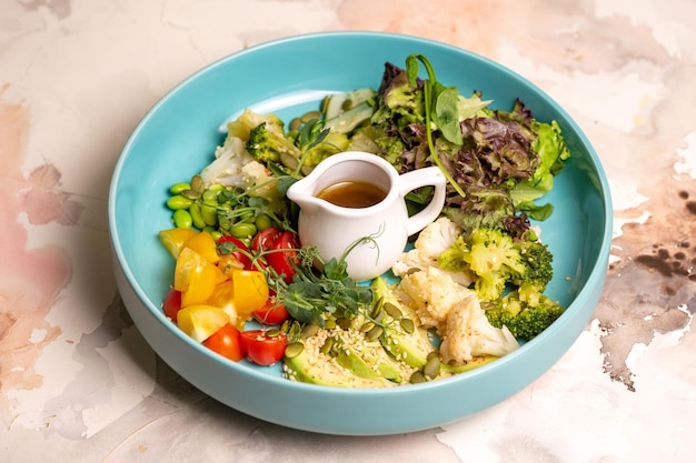 Un plato de dieta equilibrada con verduras ensalada y aderezo de ensalada