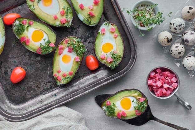 Plato de dieta Keto: botes de aguacate con cubitos de jamón, huevos de codorniz y tomates