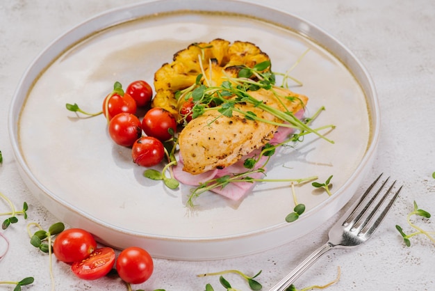 Plato dietético de filete de pollo con tomates cherry de coliflor al horno y microvegetales