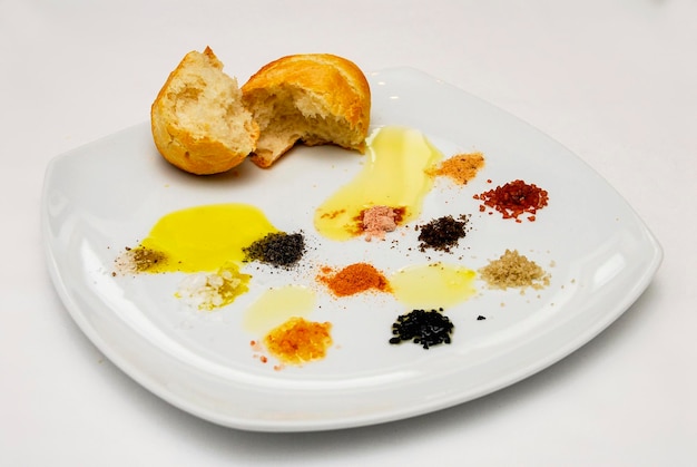 plato con diferentes tipos de sal, aceite de oliva y pan en un plato espacio de comida de fondo blanco