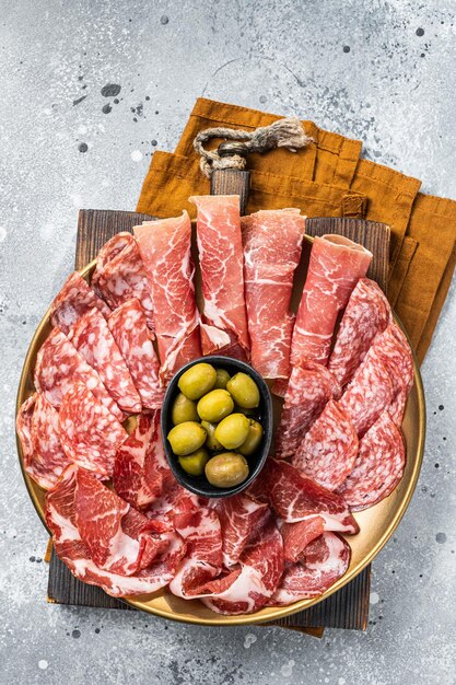 Plato de embutidos de aperitivos italianos tradicionales con Prosciutto crudo Salami y Coppa Sausage Fondo gris Vista superior