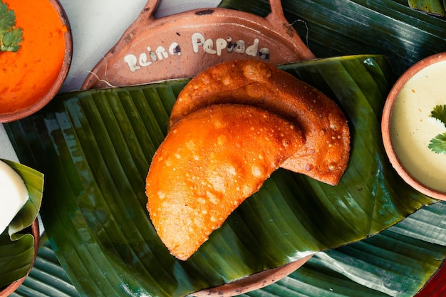 Plato de empanada venezolana sobre un fondo verde. Comida.