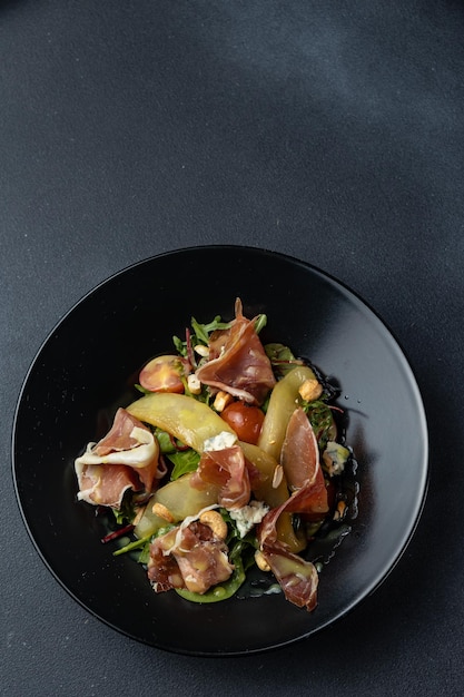 Un plato de ensalada de frutas con un fondo negro