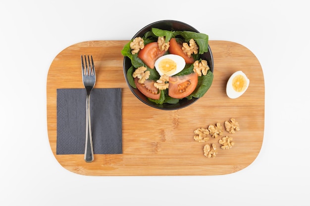 Plato de ensalada con lechuga, tomate, huevo y nueces.