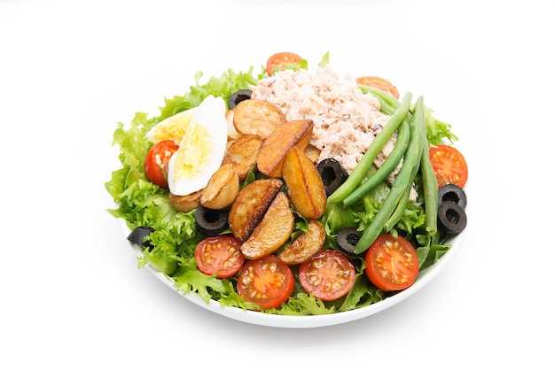 Foto un plato de ensalada nicoise con atún y patatas aislado en un fondo blanco, primer plano