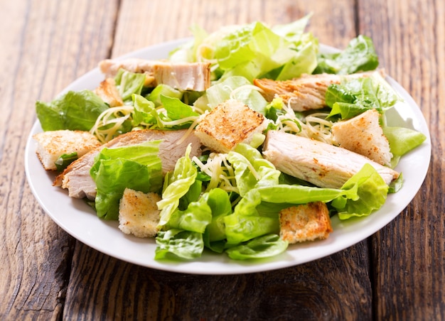 Plato de ensalada de pollo en una mesa de madera