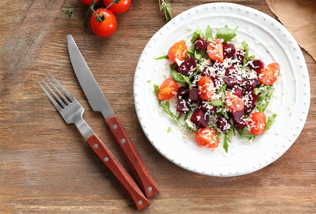 Plato con ensalada de remolacha útil sobre fondo de madera