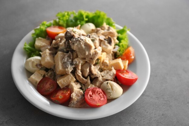 Plato con ensalada sabrosa en mesa gris