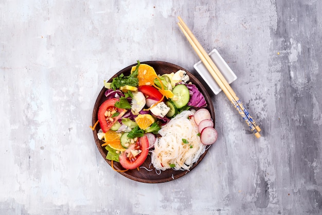 Plato de ensalada saludable con verduras y con fideos chinos y zanahorias