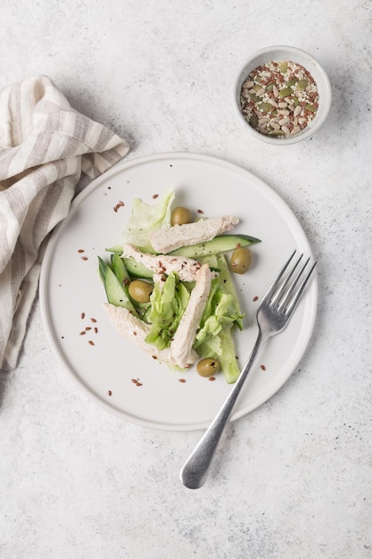 Un plato de ensalada con un tenedor y un plato de semillas de sésamo.