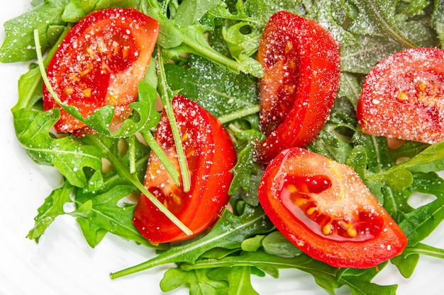 plato de ensalada tomate rúcula queso rallado aceite de oliva comida saludable comida snack en la mesa