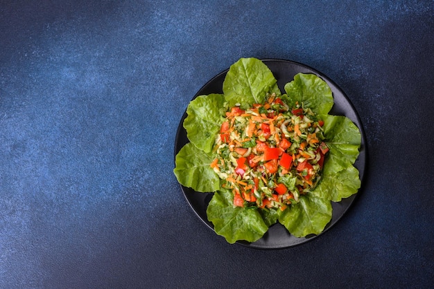 Plato de ensalada con verduras y verduras en una mesa de hormigón oscuro