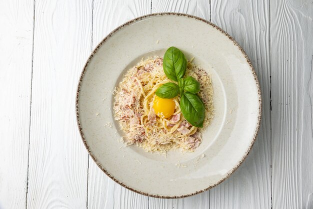 Un plato de espaguetis con yogur y un huevo pequeño encima.