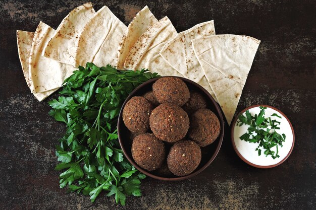 Un plato de falafel, salsa blanca, pita y perejil. Falafel fresco