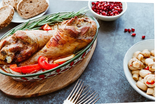 Plato festivo para las piernas de pavo asado de Acción de Gracias con verduras en una mesa con bocadillos