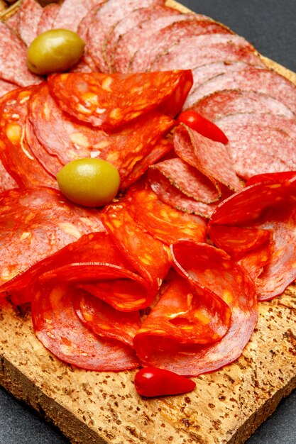 Plato de fiambre con salchichón y chorizo sobre tabla de madera de corcho