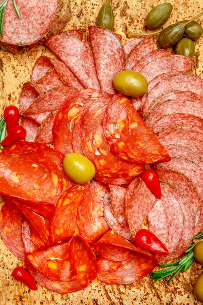 Plato de fiambre con salchichón y chorizo sobre tabla de madera de corcho