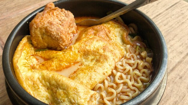 Foto un plato de fideos con un pollo y un huevo frito.