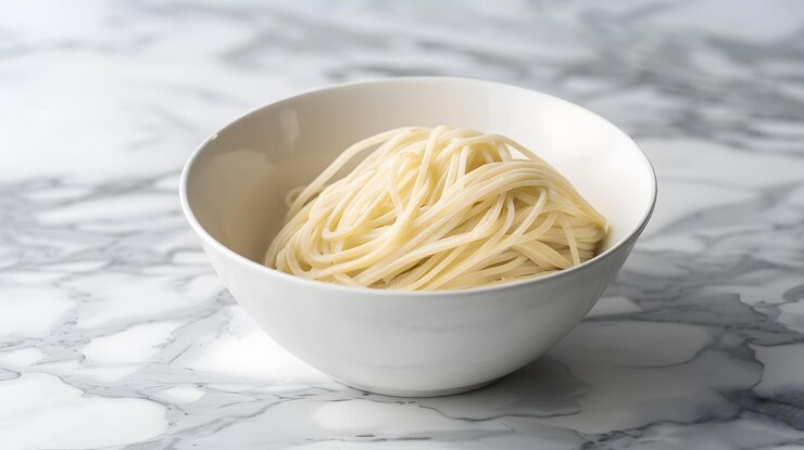 un plato de fideos secos crudos en una mesa de mármol gris