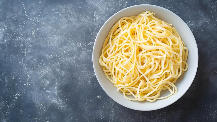 un plato de fideos secos crudos en una mesa de mármol gris