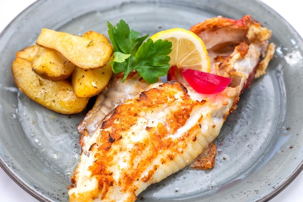 Plato de filete de escorpión rojo a la parrilla y verduras en la mesa del restaurante