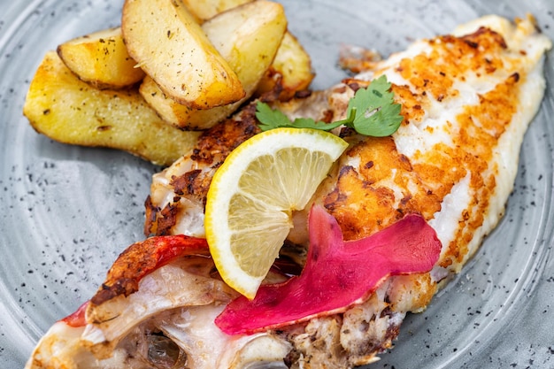 Plato de filete de escorpión rojo a la parrilla y verduras en la mesa del restaurante