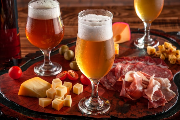 Plato frío con cerveza de barril sobre una tabla para cortar madera